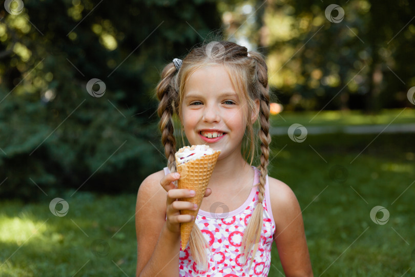 Скачать Красивая маленькая блондинка ест мороженое летом в парке. веселая девушка с мороженым. фотосток Ozero