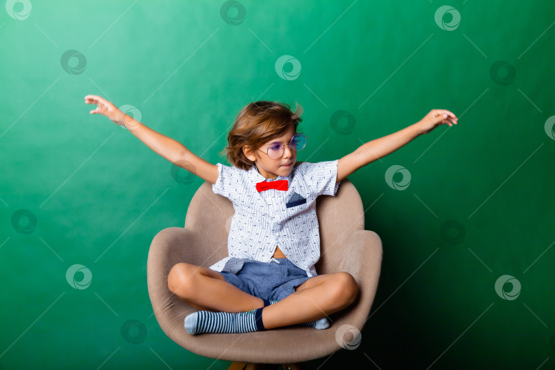 Скачать Веселый маленький мальчик в полный рост, стоящий с поднятыми руками на сером фоне фотосток Ozero