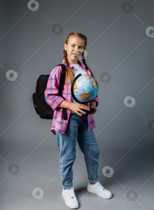 Скачать Крупным планом фотопортрет забавной милой смеющейся умной удивленной девушки, держащей в руках глобус фотосток Ozero
