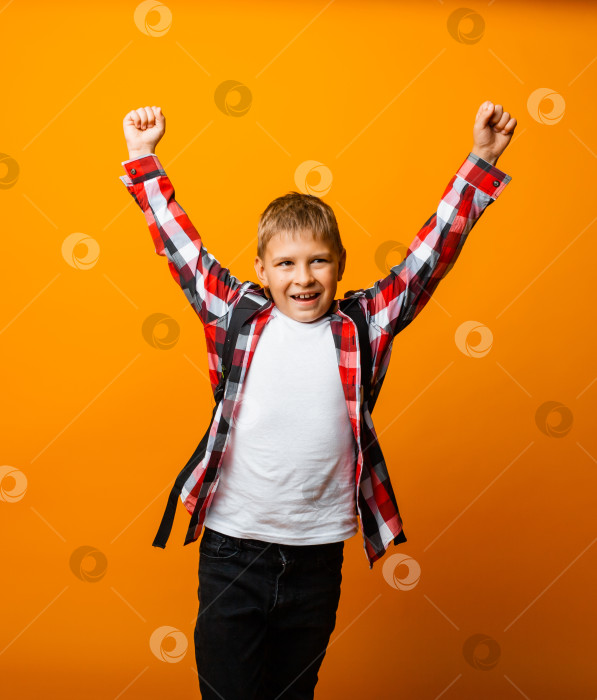 Скачать Счастливый мальчик забавно смеется, удивленно вскрикивает, поднимая руки вверх, детские эмоции. фотосток Ozero