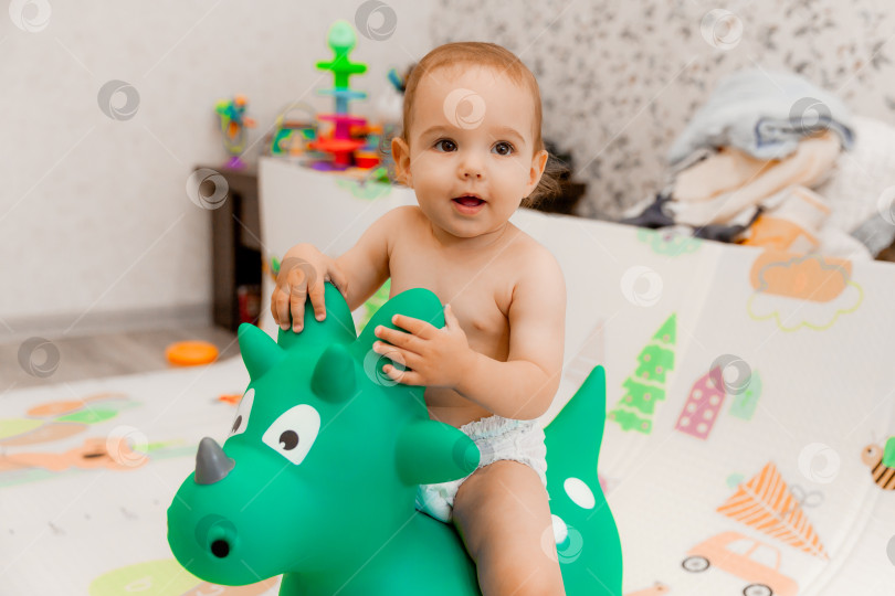 Скачать ребенок качается на каталке в форме дракона в своей комнате. игрушечный дракон. фотосток Ozero