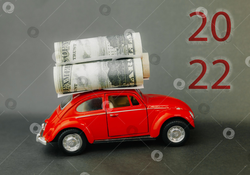 Скачать доллары, завернутые в миниатюрную модель автомобиля. надпись 2022 фотосток Ozero