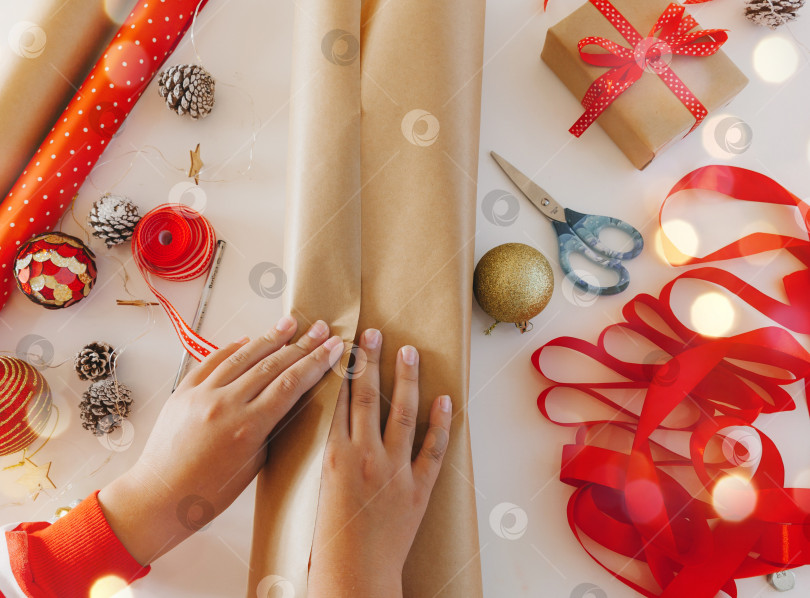 Скачать подарочные коробки из крафт-бумаги с красной лентой. вид сверху. поэтапная подарочная упаковка. новый год. Плоская поверхность фотосток Ozero