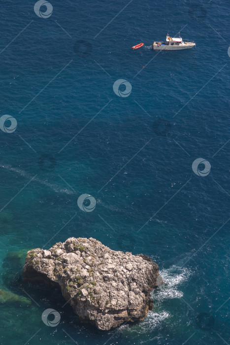 Скачать Вид на побережье острова Капри (Италия) с видом на грот »Grotta Albergo dei Marinai" и лодку фотосток Ozero