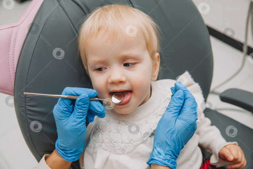 Скачать Стоматолог осматривает зубы ребенка в стоматологическом кресле. концепция медицины и стоматологии. фотосток Ozero