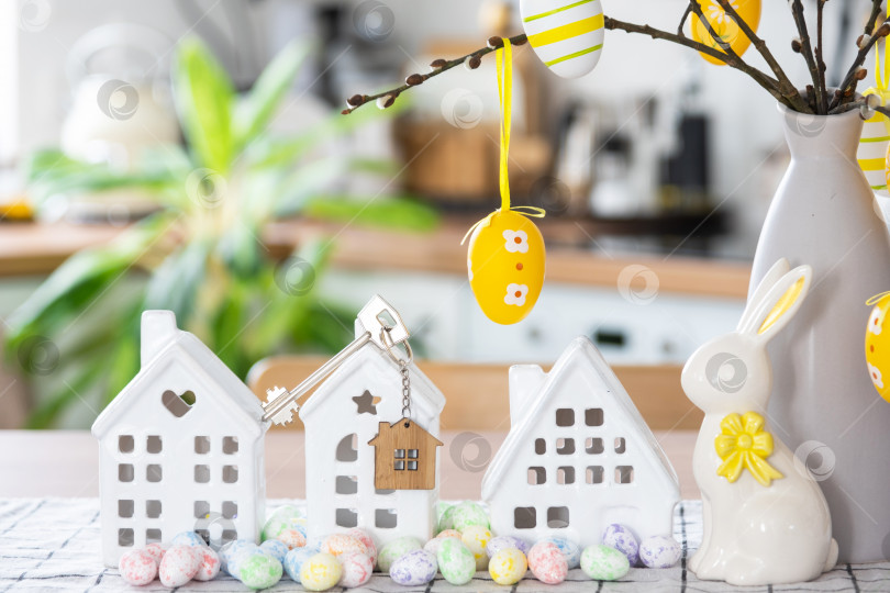 Скачать Ключ от дома уютного дома с пасхальным декором с кроликом и яйцами на кухонном столе. Строительство, дизайн, проект, переезд в новый дом, ипотека, страхование, аренда и покупка недвижимости фотосток Ozero