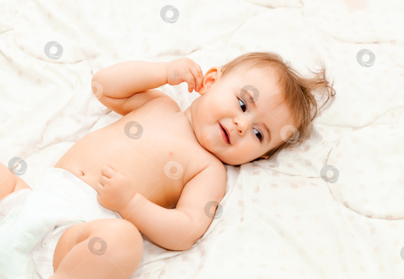 Скачать Портрет милого 6-месячного малыша, лежащего на одеяле. маленький счастливый ребенок фотосток Ozero