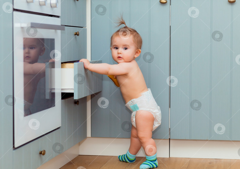 Скачать Малыш стоит возле открытого кухонного шкафа фотосток Ozero