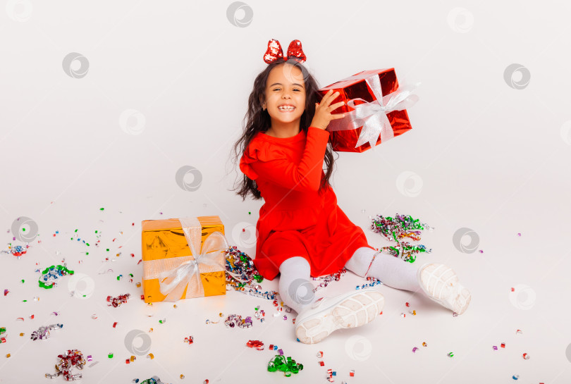 Скачать веселая девушка с подарочной коробкой на вечеринке, на которую сыплются конфетти. празднование дня рождения или нового года фотосток Ozero