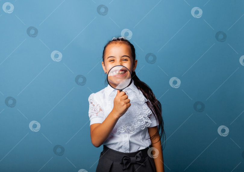 Скачать маленькая девочка держит увеличительное стекло у рта и показывает свой язычок на розовом фоне фотосток Ozero