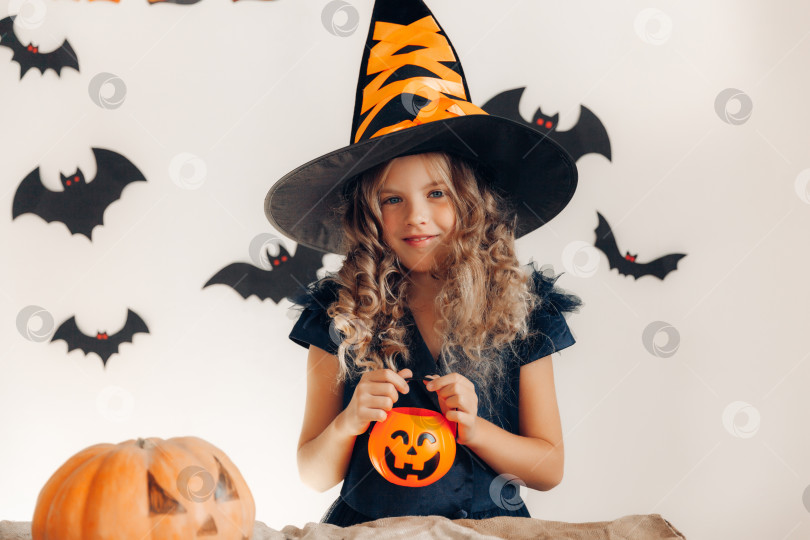 Скачать маленькая девочка, одетая как ведьма с тыквой. хэллоуин. тыква на Хэллоуин фотосток Ozero