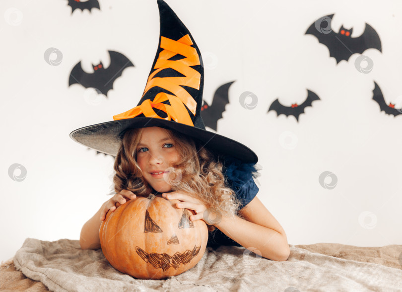 Скачать маленькая девочка, одетая как ведьма с тыквой. хэллоуин. тыква на Хэллоуин фотосток Ozero