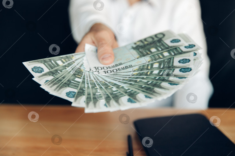 Скачать Деловой человек, демонстрирующий поклонника денег. бизнес. мужчина держит в руках деньги. фотосток Ozero