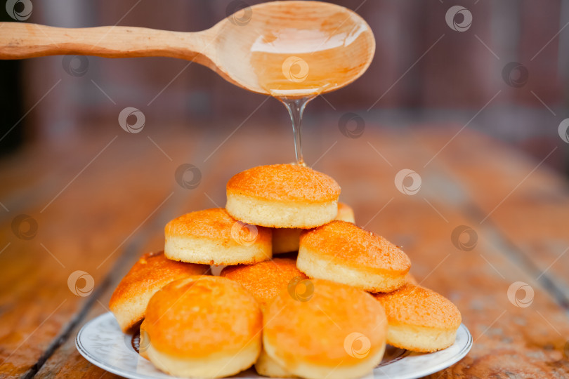 Скачать Медовый ковшик для посыпки традиционных пончиков со льдом. Вкусная сладкая еда. фотосток Ozero