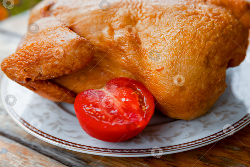 Скачать Запеченная копченая курица с помидорами на столе. фотосток Ozero