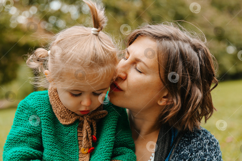 Скачать мама держит дочь на руках в парке. женщина с маленьким ребенком прогуливаются по осеннему парку. осень. фотосток Ozero