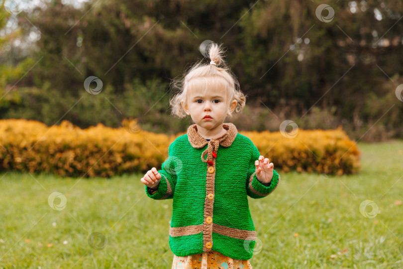 Скачать маленькая девочка смотрит в камеру. серьезный портрет маленького ребенка на фоне природы. фотосток Ozero