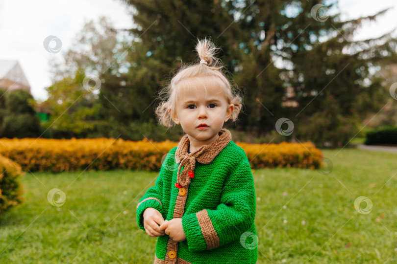 Скачать маленькая девочка смотрит в камеру. серьезный портрет маленького ребенка на фоне природы. фотосток Ozero