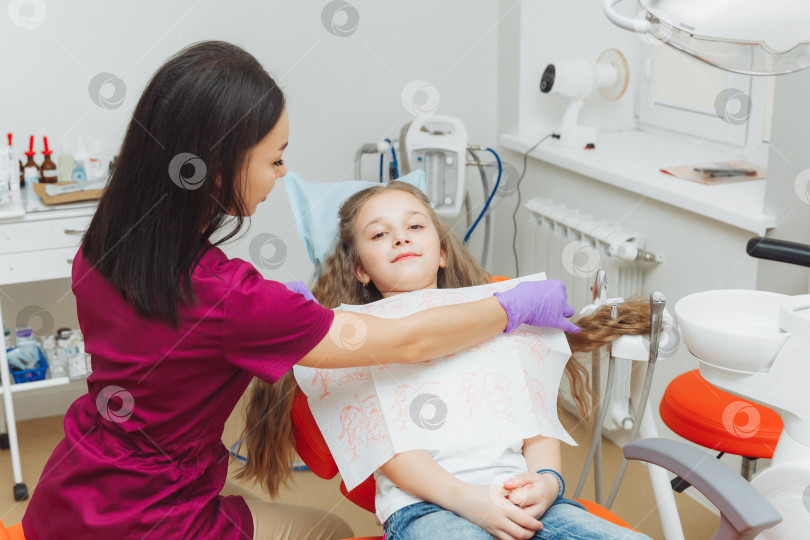Скачать стоматолог накладывает на пациента зубную салфетку. Подготовка пациента к стоматологическому осмотру фотосток Ozero