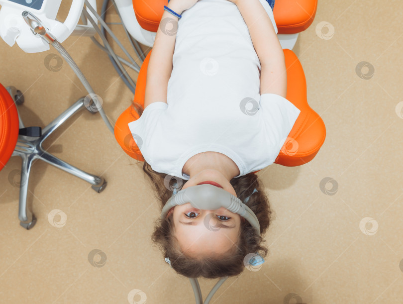 Скачать маленькая девочка в успокаивающей маске. Лечение детских зубов закисью азота. детская стоматология. фотосток Ozero