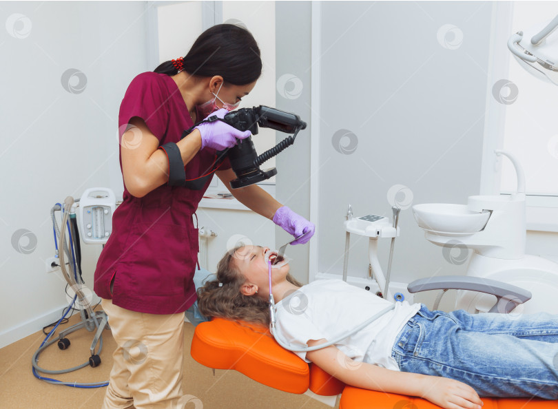 Скачать фотопротокол в стоматологии. врач фотографирует зубы девочки, осматривает ее рот. детская стоматология. фотосток Ozero