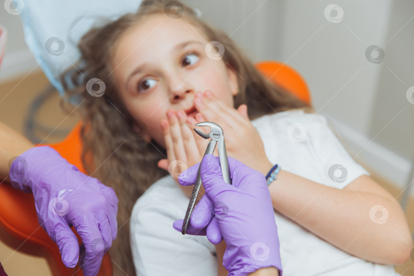 Скачать портрет испуганной маленькой девочки в кабинете дантиста. стоматолог удалил зуб маленькой девочке фотосток Ozero