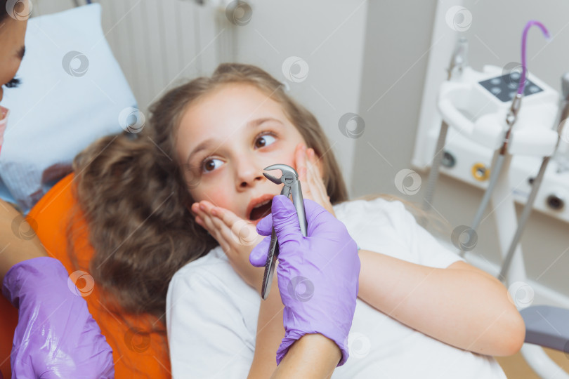 Скачать портрет испуганной маленькой девочки в кабинете дантиста. стоматолог удалил зуб маленькой девочке фотосток Ozero