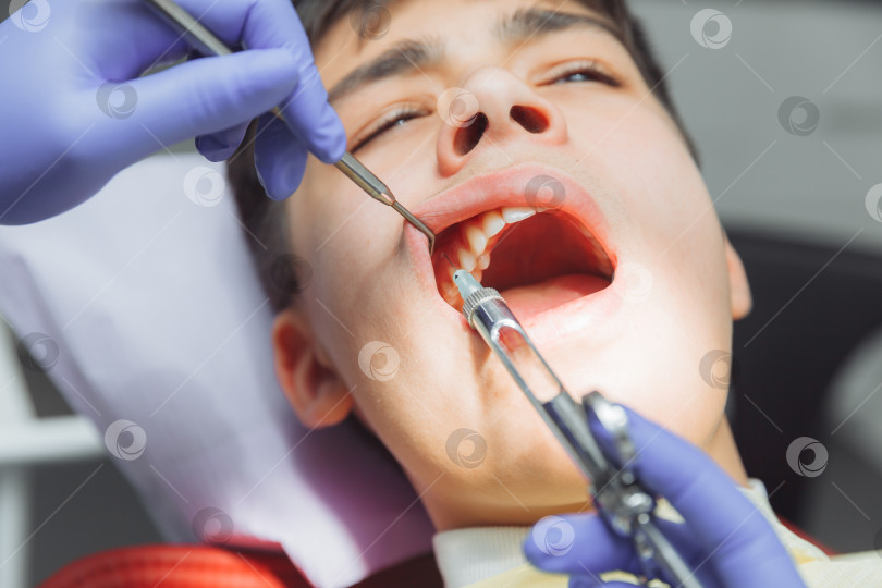 Скачать женщина-стоматолог в защитном снаряжении делает ребенку обезболивающий укол фотосток Ozero