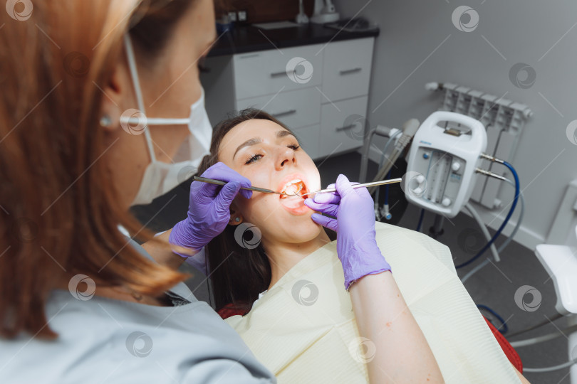 Скачать Стоматолог осматривает зубы пациентки крупным планом. современная стоматология фотосток Ozero