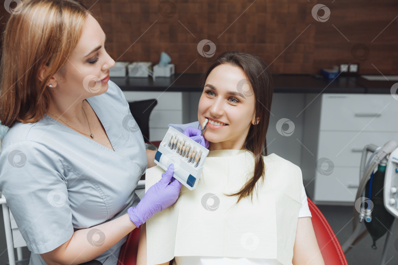 Скачать Подбор правильного цвета зубов для профессионального косметического отбеливания у стоматолога. врач подбирает зубы для пациента. фотосток Ozero