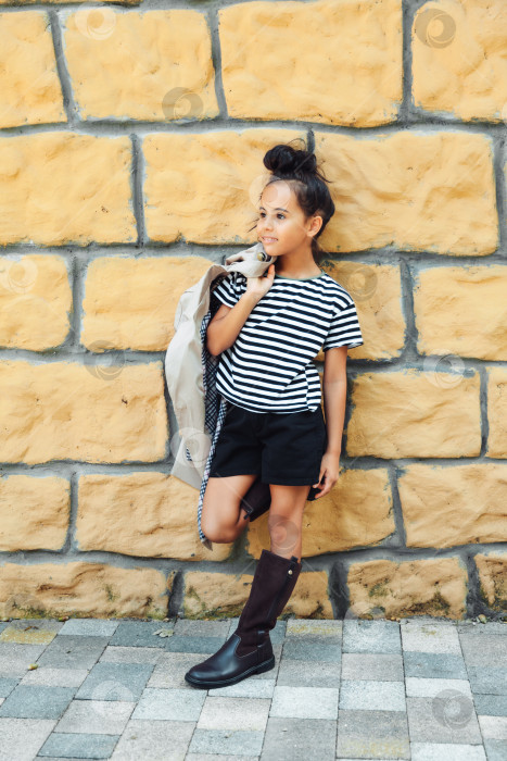 Скачать маленькая девочка в полосатой толстовке позирует на фоне кирпичной стены. детская осенняя мода. поколение z фотосток Ozero