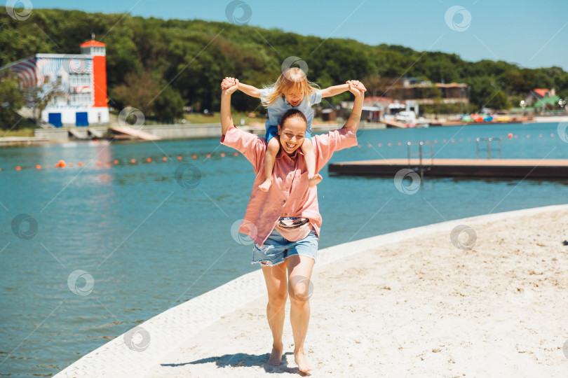Скачать Счастливая семья. Молодая красивая мама и ее сын весело проводят время на пляже. эмоции, чувства, радость. фотосток Ozero