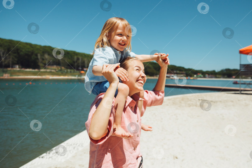 Скачать Счастливая семья. Молодая красивая мама и ее сын весело проводят время на пляже. эмоции, чувства, радость. фотосток Ozero