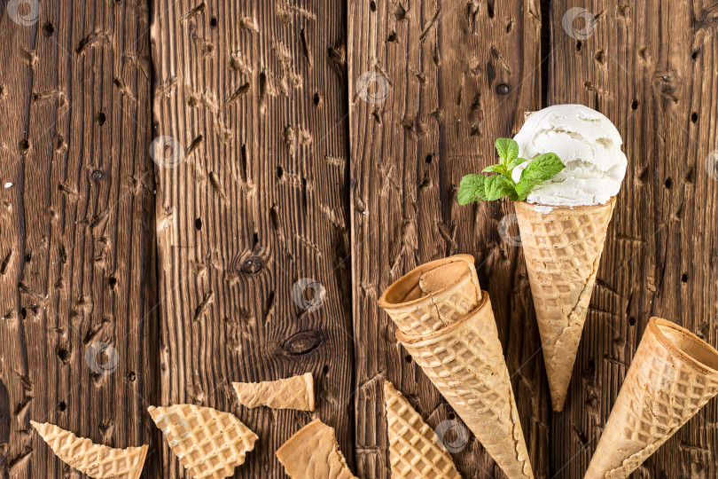 Скачать Вид сверху на белое мороженое в вафельном рожке на деревенском фоне. фотосток Ozero