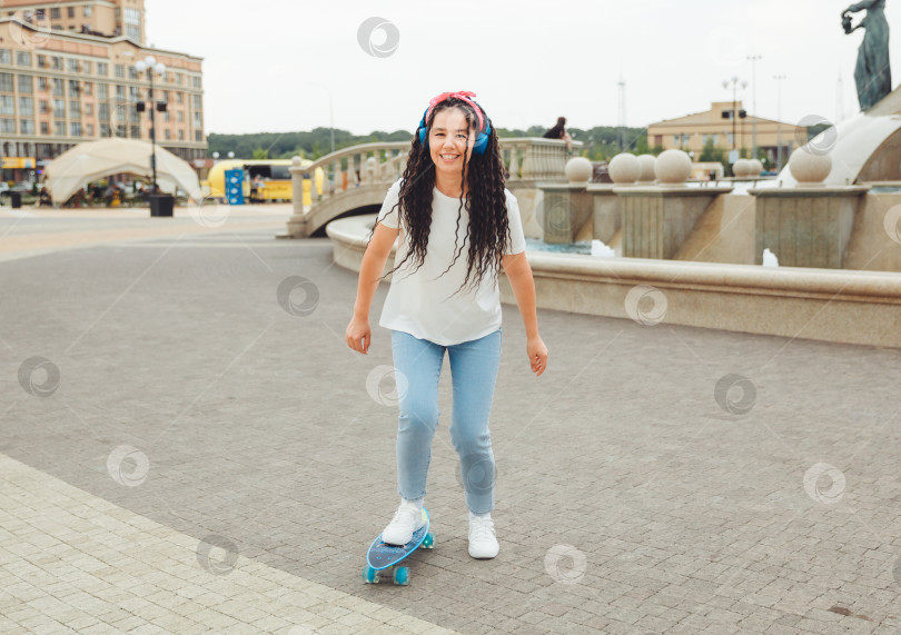 Скачать Красивая молодая девушка с дредами катается на скейтборде в солнечную погоду. поколение z фотосток Ozero
