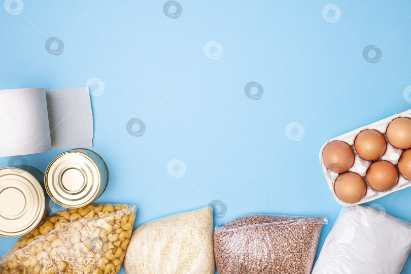 Скачать Доставка еды. Рис, гречка, макароны, консервы, сахар, туалетная бумага на синем фоне. фотосток Ozero