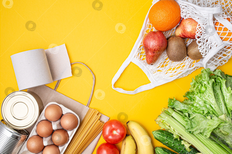 Скачать Бумажный пакет с продуктами, консервами, помидорами, огурцами, бананами на желтом фоне фотосток Ozero