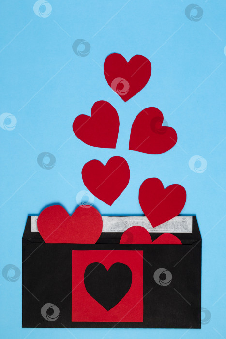 Скачать Черный конверт с красным сердечком на модном синем фоне. фотосток Ozero