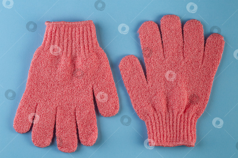 Скачать Пара розовых массажных перчаток для душа на синем фоне фотосток Ozero