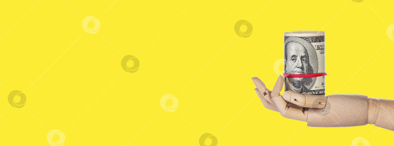 Скачать Деревянная рука с деньгами, выделенная на желтом фоне фотосток Ozero