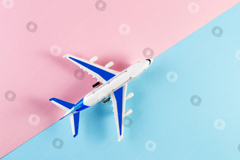 Скачать Модель самолета, самолетик на розовом и голубом фоне. Концепция летнего путешествия фотосток Ozero