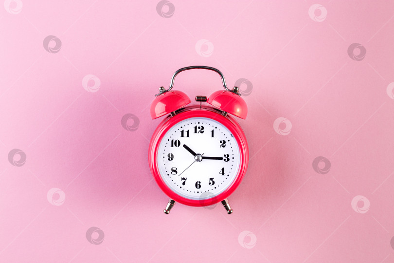 Скачать Красный винтажный будильник на светло-розовом фоне. Концепция тайм-менеджмента фотосток Ozero