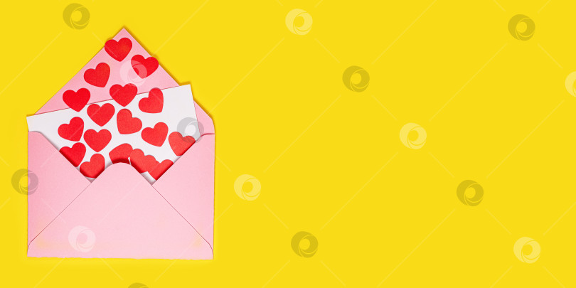 Скачать Открытка на День Святого Валентина. Бумажные красные сердечки вылетают из розового бумажного конверта на желтом фоне. Бумажное искусство в день святого Валентина. фотосток Ozero