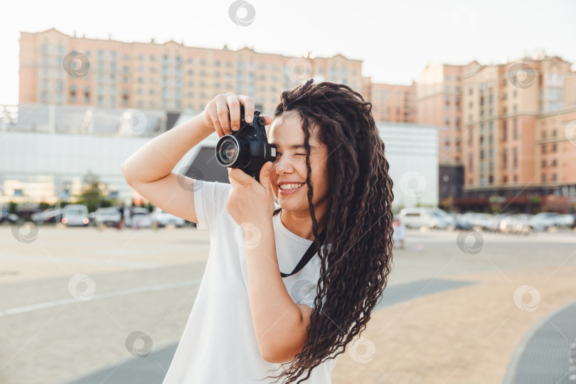 Скачать Молодой фотограф с профессиональной уличной камерой. Место для текста. девушка с дредами фотографирует городской пейзаж. фото. фотосток Ozero