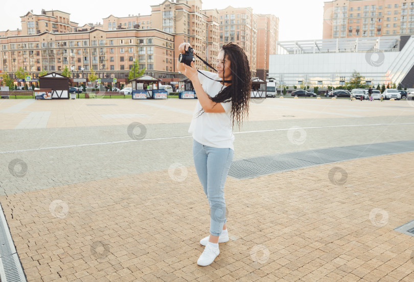 Скачать Молодой фотограф с профессиональной уличной камерой. Место для текста. девушка с дредами фотографирует городской пейзаж. фото. фотосток Ozero