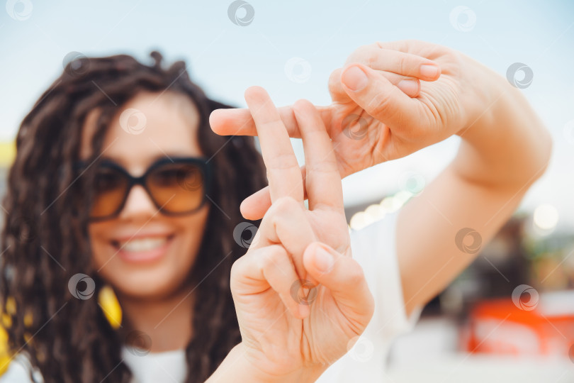 Скачать Хэштег символа жеста "Руки показывают жест" является вирусным, веб, социальные сети, network. молодая женщина с дредами показывает жест с хэштегом на улице. фотосток Ozero