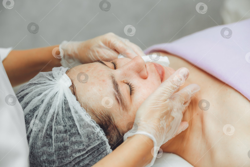Скачать Косметолог очищает кожу клиентки салона красоты перед процедурой и массажем лица. Концепция красоты и здоровья. косметология. кожа, покрытая прыщами фотосток Ozero