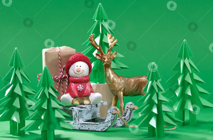 Скачать Рождественская сцена. Рождественский снеговик с подарком на деревянных санках. фотосток Ozero