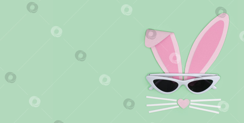 Скачать Поздравительная открытка с Пасхой. Мордочка кролика из розовой бумаги с солнцезащитными очками фотосток Ozero