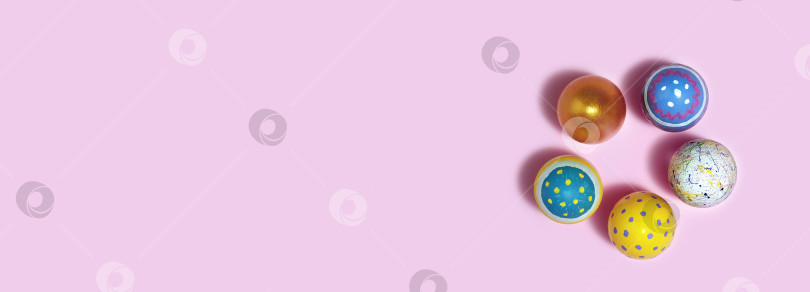 Скачать Разноцветные пасхальные яйца на розовом фоне. Яйца на бумажном фоне. Вид сверху фотосток Ozero